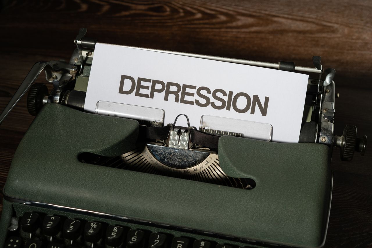 team-02 A vintage typewriter with the word 'Depression' typed on paper, conveying a mental health theme.
