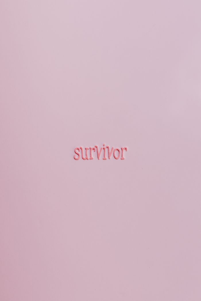 The Art of Drawing Readers In: Your attractive post title goes here Pink surface with the word 'survivor', symbolizing strength and cancer awareness.
