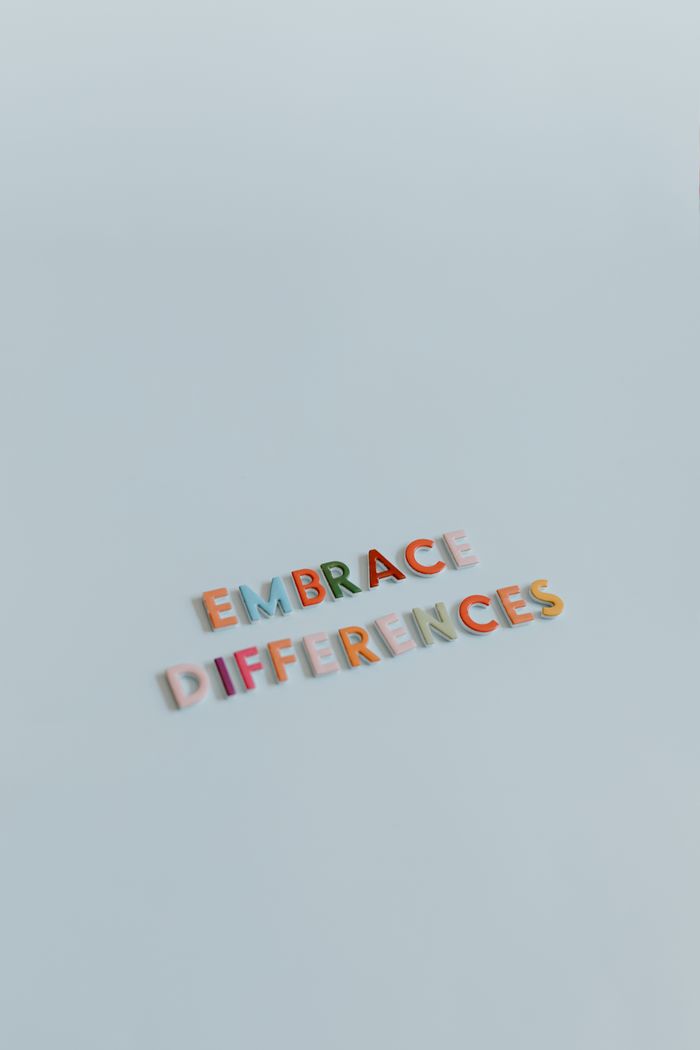 Colorful letters spelling 'Embrace Differences' on a light blue background, promoting diversity and inclusion.